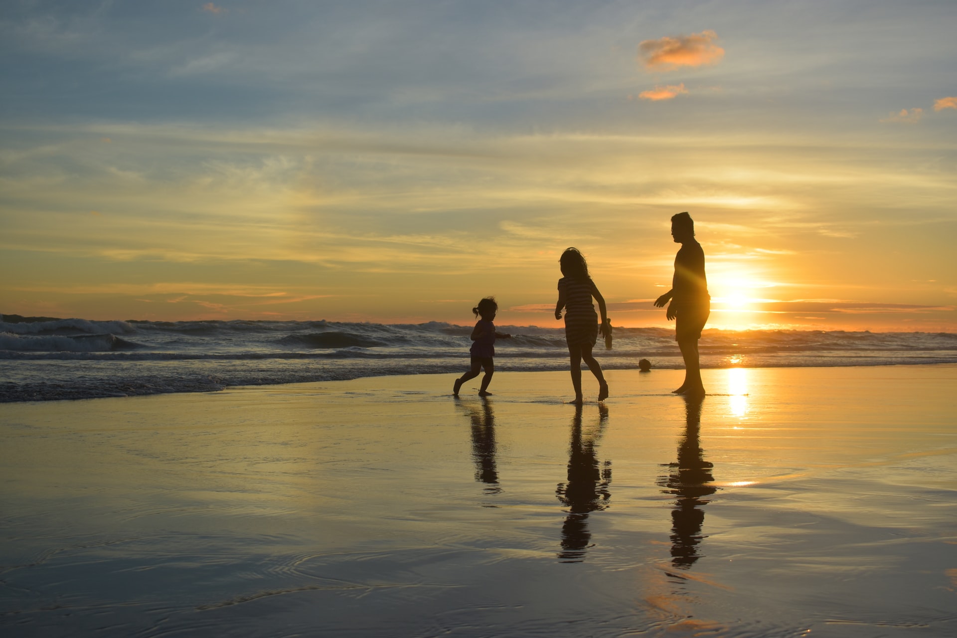 Family playing at the seashore during a sunset