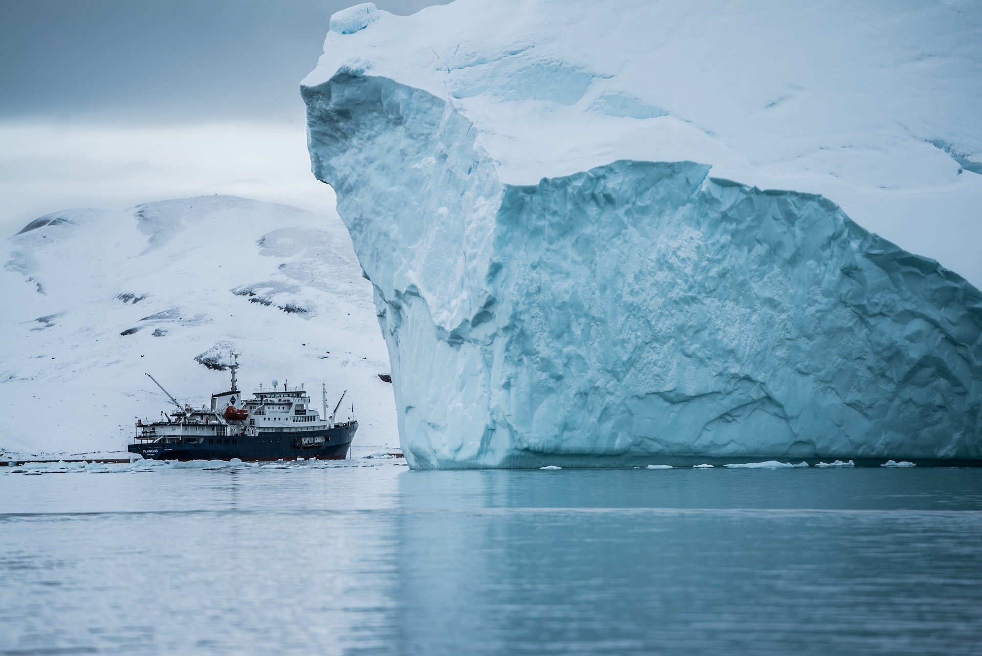 Boat beside large iceberg