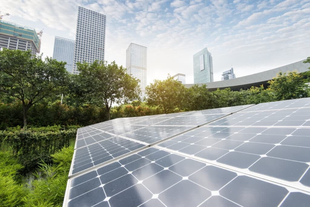 A solar energy plant surrounded by greenery and buildings.