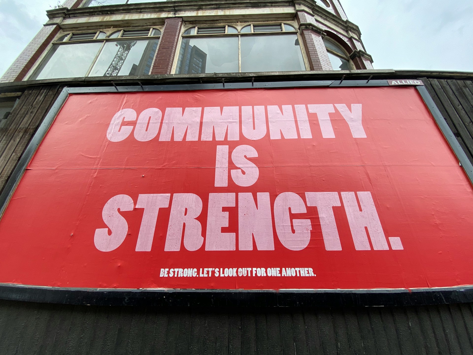 A red billboard with the words "Community is Strength".
