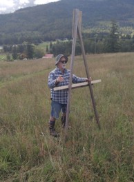Man with A-frame and level to survey landscape
