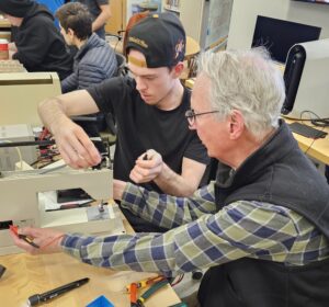 Two volunteers fixing a sewing machine together